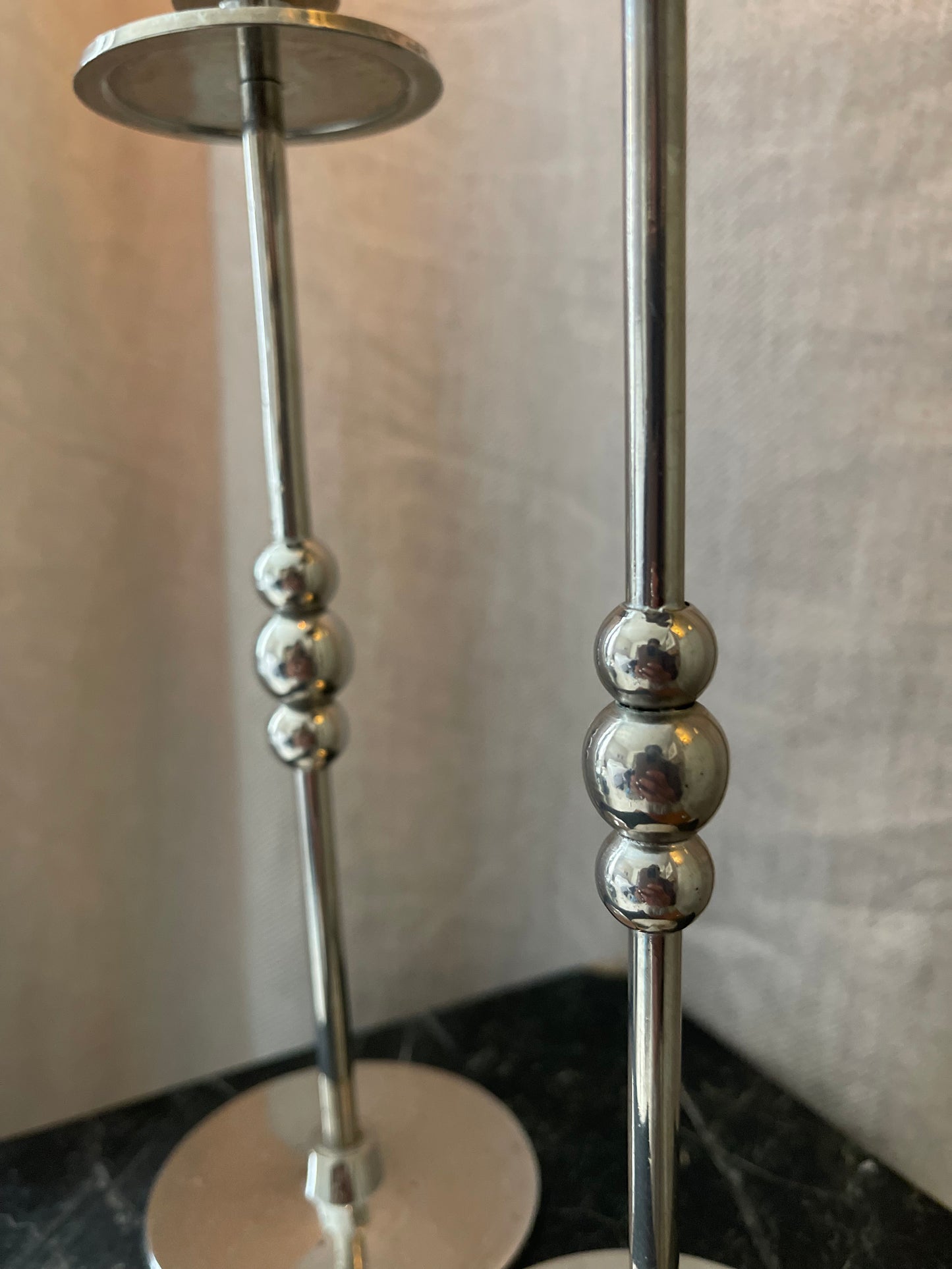 A pair of chrome plated candlesticks with beads