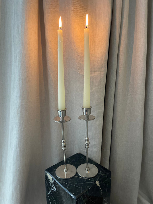 A pair of chrome plated candlesticks with beads