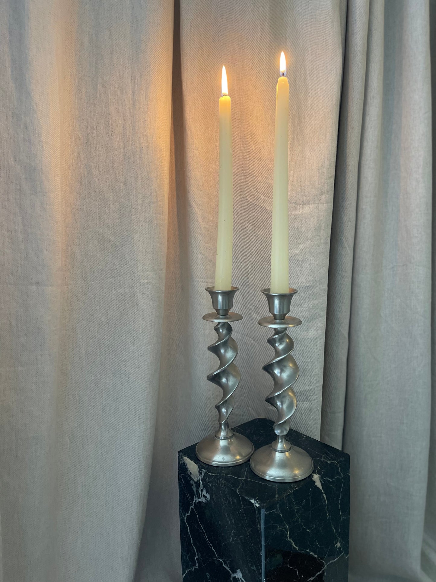 A pair of twisted silvertone candlesticks