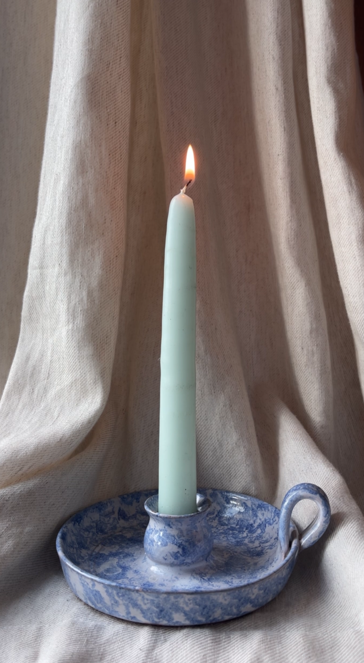 Blue candle stick holder with base and handle. 